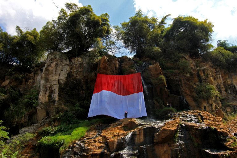 Anggota Forum Komunikasi Siswa pecinta Alam Kota Bandung (FORKOSISPAKOTAB) hormat ke bendera raksasa merah putih di obyek wisata curug batu templek, di Jalan Cikawari, Desa Mekar Jaya, Kecamtan Cimenyan, Kabupaten Bandung, Rabu ( 17/8). Bendera berukuran 15x6 meter ini di kibarkan di atas tebing obyek wisata curug batu templek. DICKY ADAM SIDIQ